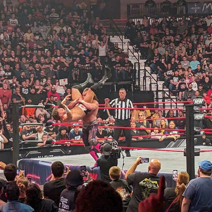 Kenny Omega powerbombing MJF through a table (not shown)